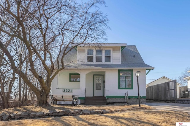 bungalow-style home featuring covered porch and a shingled roof