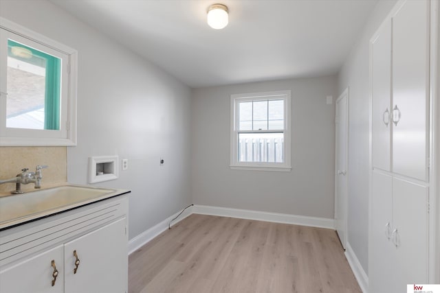 laundry area with light wood finished floors, baseboards, hookup for a washing machine, electric dryer hookup, and a sink