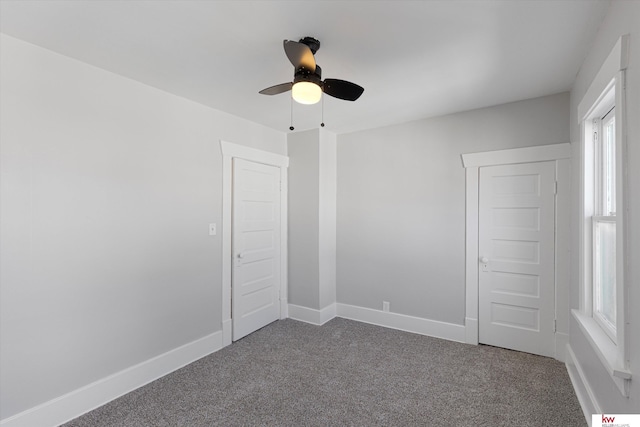 unfurnished room featuring a ceiling fan, carpet, and baseboards