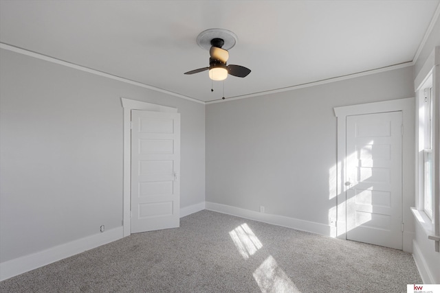 spare room with ornamental molding, ceiling fan, carpet floors, and baseboards