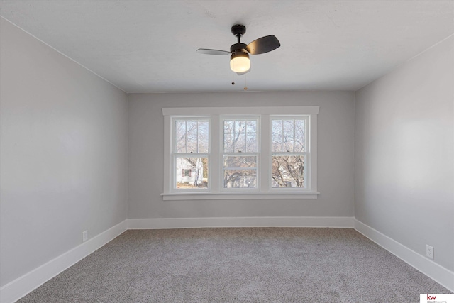 carpeted spare room with baseboards and a ceiling fan