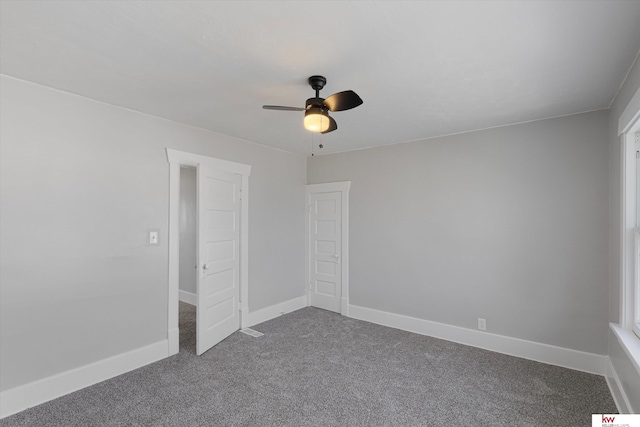 unfurnished bedroom featuring dark colored carpet, a ceiling fan, and baseboards