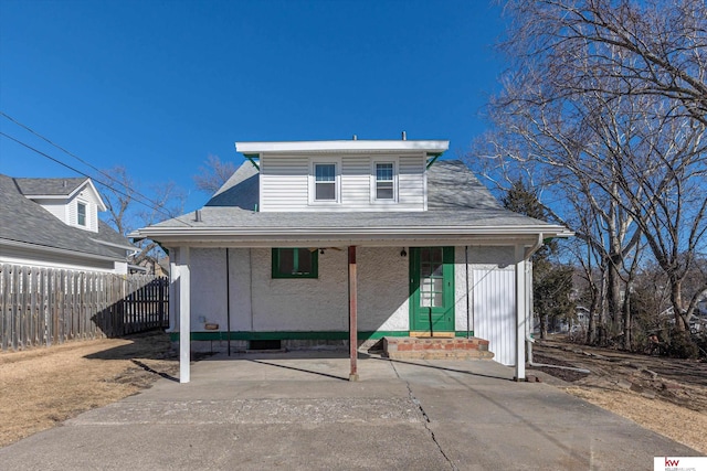 bungalow-style home featuring a shingled roof, a porch, and fence