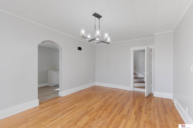 empty room with light wood-type flooring, stairway, baseboards, and arched walkways