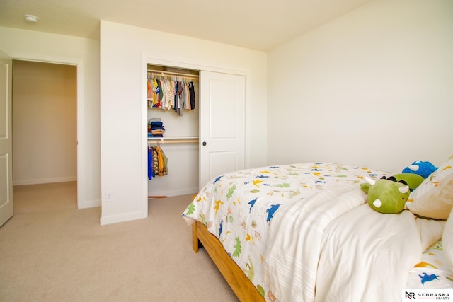 bedroom featuring light carpet, a closet, and baseboards