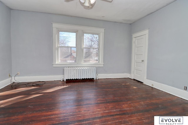 empty room with radiator, hardwood / wood-style flooring, ceiling fan, and baseboards