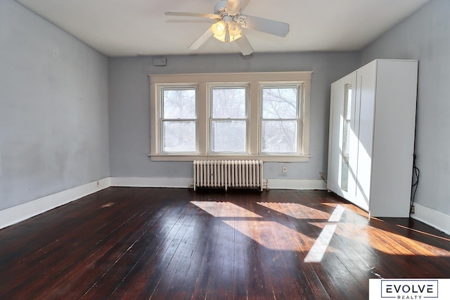 spare room with ceiling fan, radiator heating unit, hardwood / wood-style flooring, and baseboards