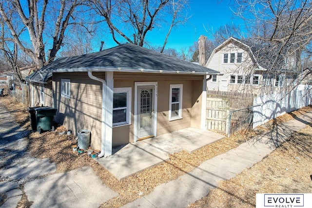 bungalow-style house featuring a shingled roof, fence, and a gambrel roof