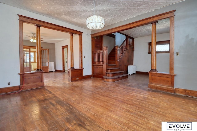 interior space with ornate columns, hardwood / wood-style flooring, an ornate ceiling, and radiator