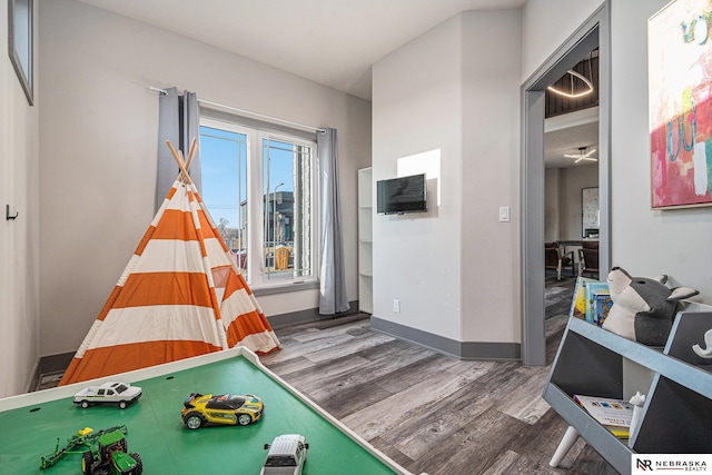 game room with baseboards and wood finished floors