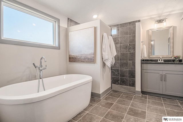 bathroom featuring vanity, a soaking tub, a healthy amount of sunlight, and a walk in shower