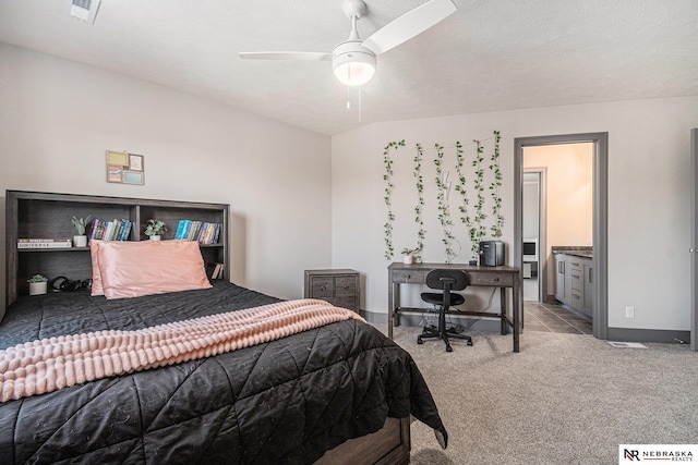 carpeted bedroom with visible vents, baseboards, a ceiling fan, and ensuite bathroom