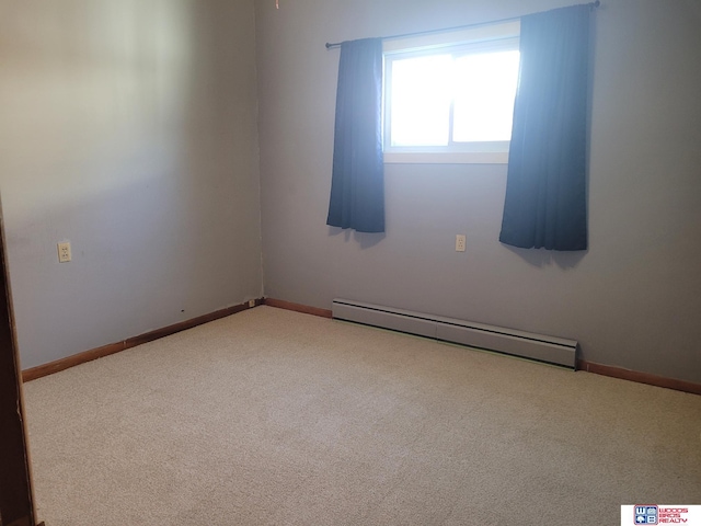 spare room featuring carpet floors, a baseboard radiator, and baseboards