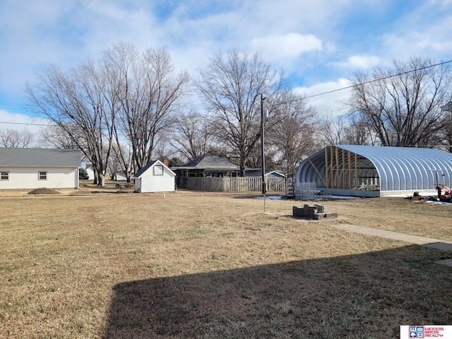 view of yard featuring an outbuilding, a carport, and fence