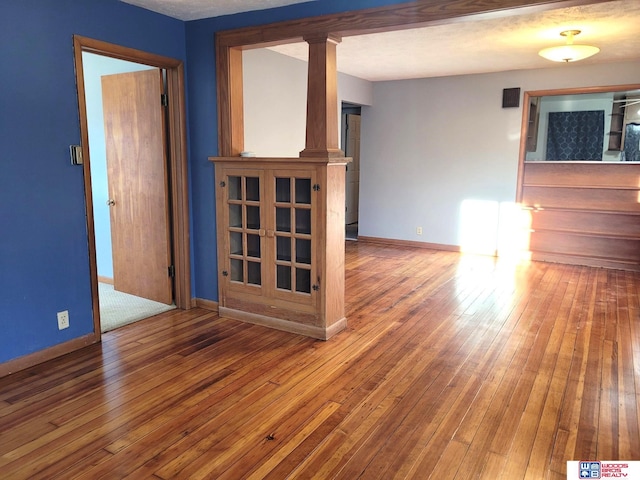 spare room with hardwood / wood-style floors and baseboards