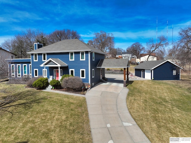 colonial-style house featuring a front lawn, concrete driveway, an outbuilding, and a chimney