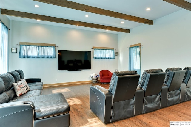 living room with beam ceiling, wood finished floors, and a wealth of natural light