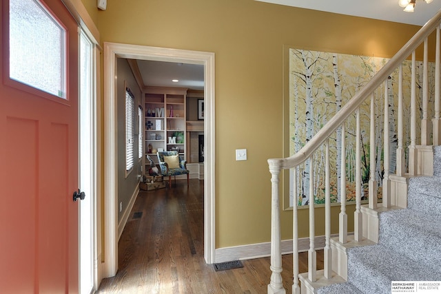 entrance foyer featuring wood finished floors, stairway, baseboards, and visible vents