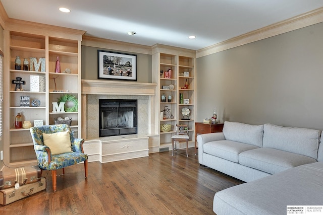 living area featuring visible vents, dark wood finished floors, ornamental molding, a premium fireplace, and recessed lighting