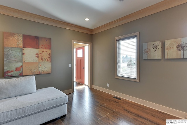 interior space featuring dark wood finished floors, baseboards, visible vents, and ornamental molding