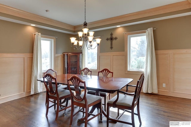 dining space with dark wood-style floors, visible vents, wainscoting, a decorative wall, and a chandelier