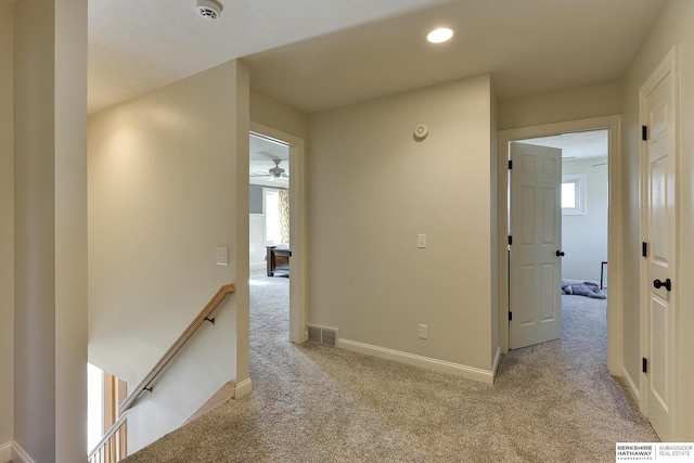 corridor with visible vents, an upstairs landing, light carpet, recessed lighting, and baseboards