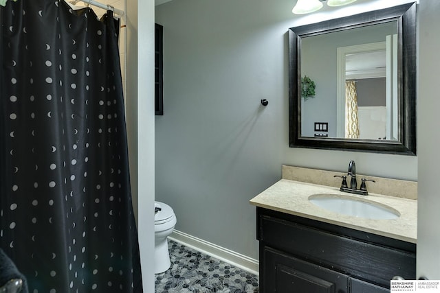 bathroom with vanity, toilet, a shower with curtain, and baseboards