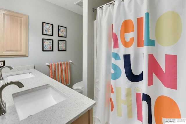 full bathroom featuring vanity, a shower with shower curtain, toilet, and visible vents