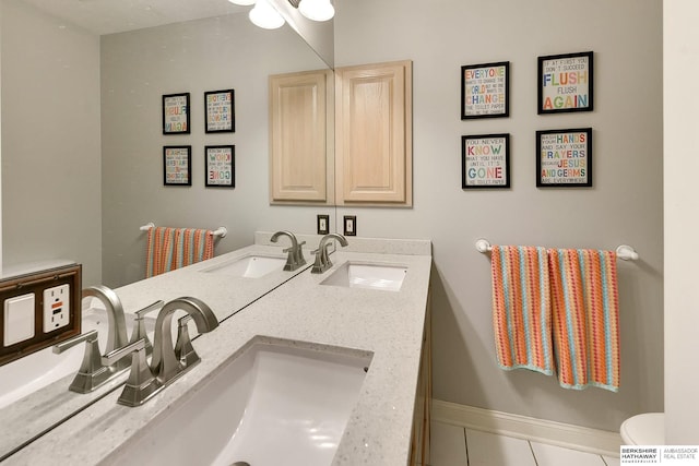 bathroom with a sink, double vanity, and tile patterned floors