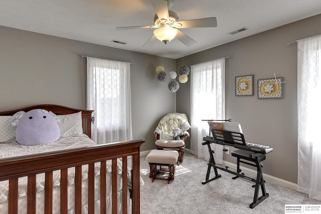 carpeted bedroom with visible vents, multiple windows, and baseboards