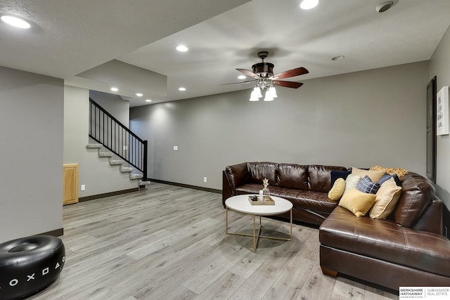 living room with stairway, recessed lighting, light wood-style floors, and baseboards