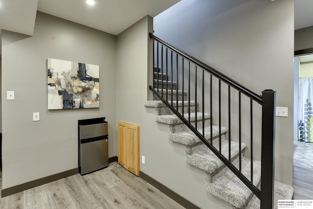 stairway with baseboards and wood finished floors