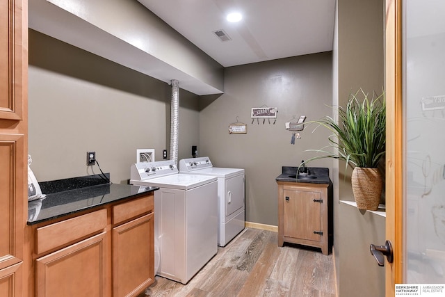 washroom with washer and clothes dryer, visible vents, cabinet space, and light wood finished floors