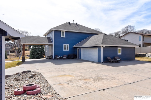 exterior space featuring roof with shingles, concrete driveway, and an attached garage