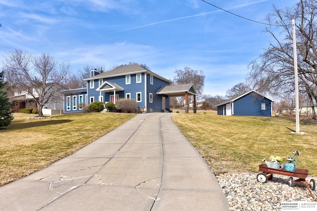 view of front facade featuring an attached carport, concrete driveway, and a front yard