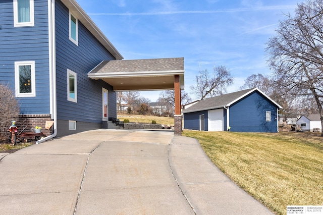 view of side of property featuring an outbuilding, a yard, and roof with shingles