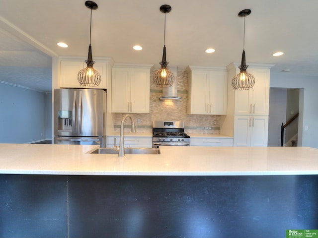 kitchen with stainless steel appliances, a sink, white cabinets, light countertops, and wall chimney range hood