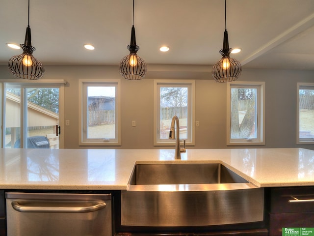 kitchen with light stone counters, recessed lighting, and a sink