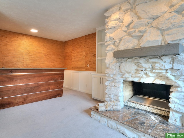 interior space with light carpet and a stone fireplace