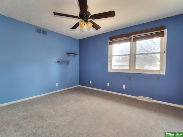 unfurnished room with carpet floors, visible vents, and baseboards