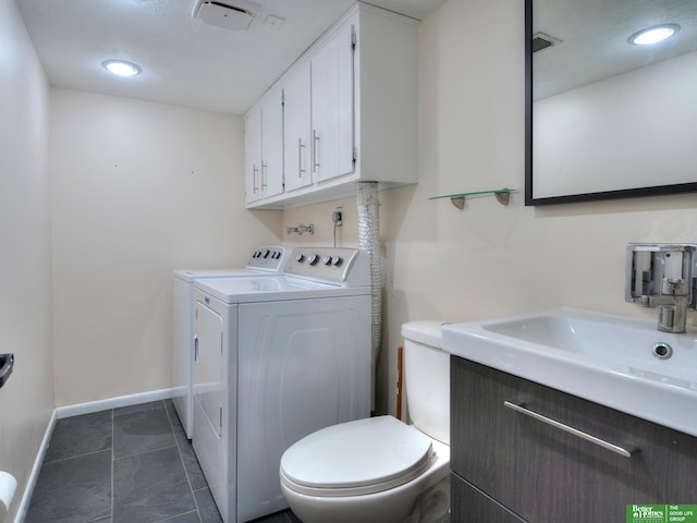 laundry area featuring laundry area, baseboards, visible vents, washer and clothes dryer, and a sink