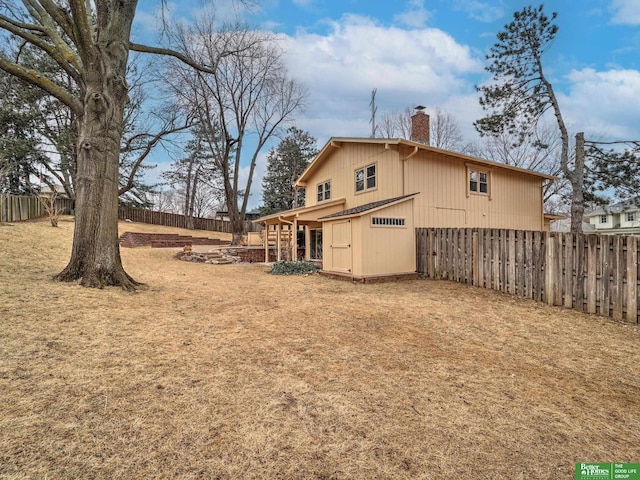 exterior space with a fenced backyard and a chimney