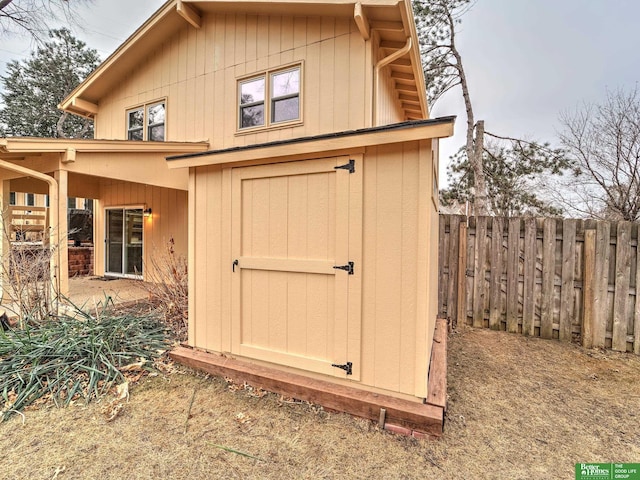 view of shed featuring fence