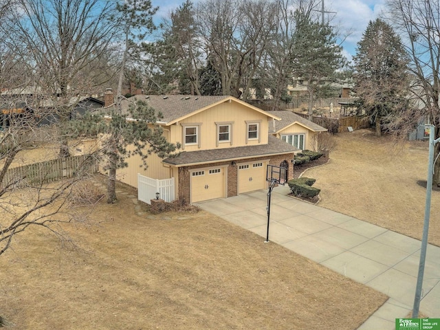 traditional-style house with a garage, brick siding, fence, concrete driveway, and a front lawn