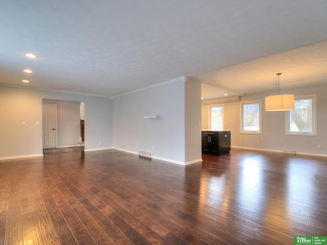 unfurnished living room with dark wood-type flooring, crown molding, and baseboards