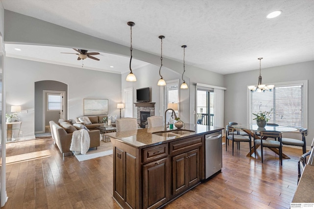 kitchen with dishwasher, dark wood-type flooring, a fireplace, and a sink