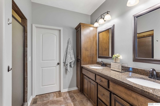 full bathroom with a sink, a shower stall, and double vanity