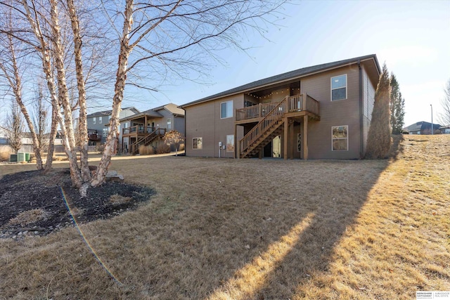 view of front of property featuring a front yard, stairway, and a wooden deck