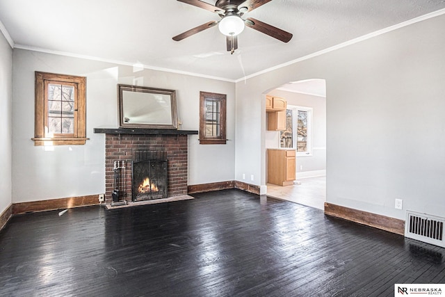 unfurnished living room with crown molding, visible vents, and wood finished floors