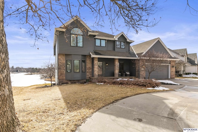 view of front facade with an attached garage, a porch, concrete driveway, and brick siding